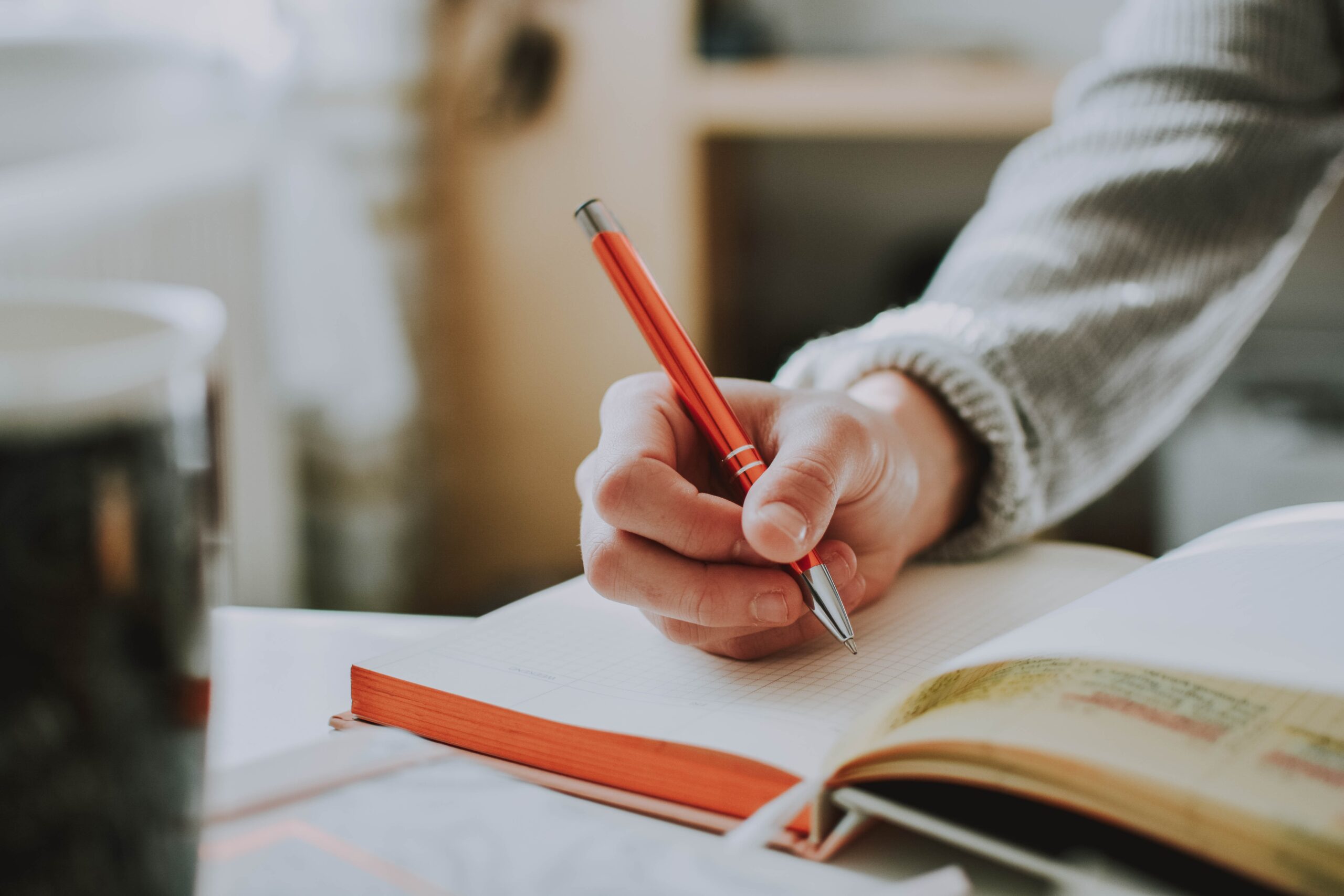 A close-up photo of a person writing in a journal.