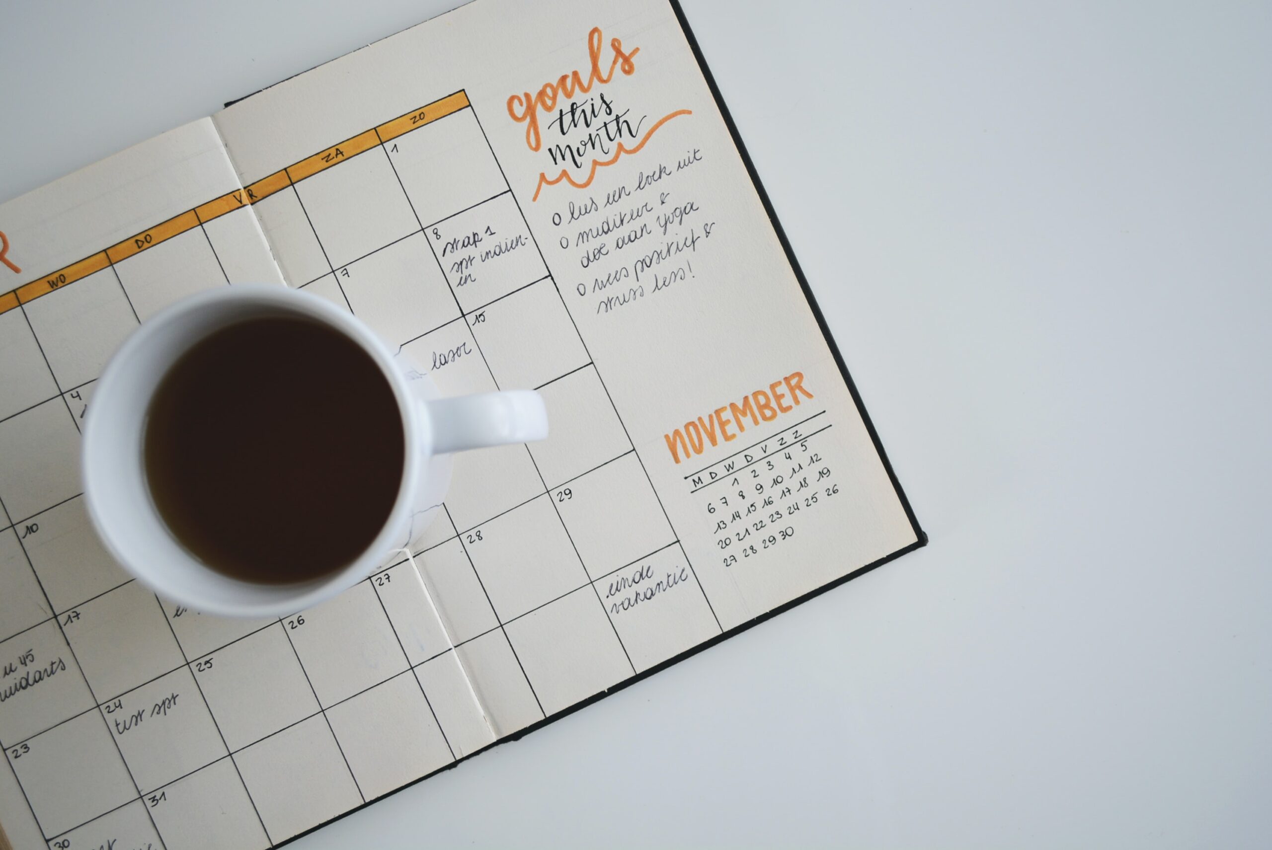a coffee mug on top of a planner